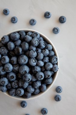 Gri arka planda bir kasede organik yaban mersini, üst manzara. 