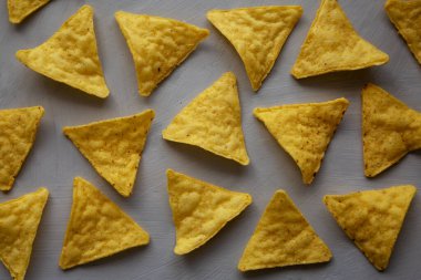 Gri arka planda ev yapımı tuzlu tortilla cipsi..