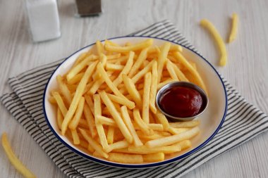 Homemade American French Fries with Ketchup on a Plate, side view. clipart