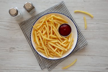 Homemade American French Fries with Ketchup on a Plate, top view. clipart