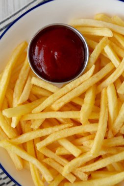 Homemade American French Fries with Ketchup on a Plate, top view. Close-up. clipart