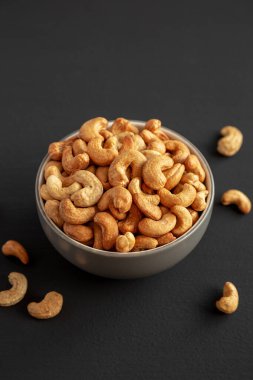 Siyah arka planda, bir kasede kızartılmış organik kaju..