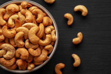 Siyah arka planda, bir kasede kızarmış organik kaju, üst görünümde.. 