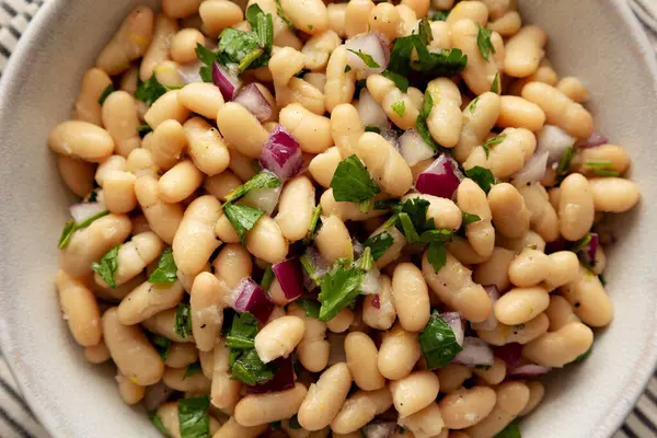 stock image Homemade White Bean Salad with Herbs and Onion in a Bowl, top view. Flat lay, overhead, from above.