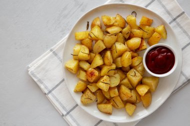 Tabakta ketçaplı ev yapımı fırın fırın patatesleri, üst manzara. Boşluğu kopyala.