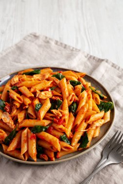 Homemade One-Pot Spinach And Tomato Pasta on a Plate, side view. Copy space. clipart