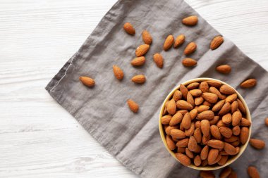 Kavrulmuş organik badem, bir kâse içinde, üst manzara. Dümdüz, tepeden, yukarıdan.