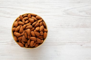 Kavrulmuş organik badem, bir kâse içinde, üst manzara. Dümdüz, tepeden, yukarıdan.