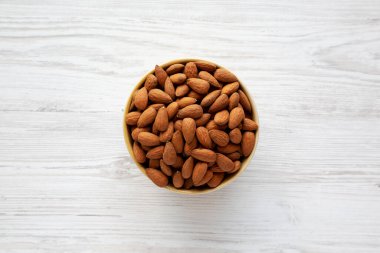 Kavrulmuş organik badem, bir kâse içinde, üst manzara. Dümdüz, tepeden, yukarıdan.