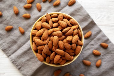 Kavrulmuş organik badem, bir kâse içinde, üst manzara. Dümdüz, tepeden, yukarıdan.