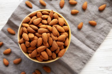 Kavrulmuş organik badem, bir kâse içinde, üst manzara. Dümdüz, tepeden, yukarıdan.