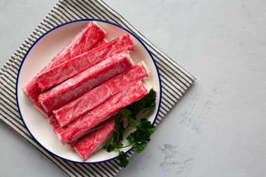 Tabaktaki organik taklit yengeç eti çubukları, üst manzara. Dümdüz, tepeden, yukarıdan. Boşluğu kopyala.