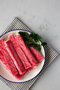 Tabaktaki organik taklit yengeç eti çubukları, üst manzara. Dümdüz, tepeden, yukarıdan. Boşluğu kopyala.