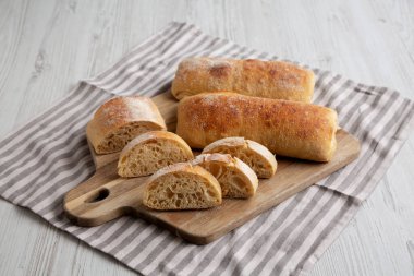 Homemade Sliced Ciabatta Bread on a wooden board, side view. clipart