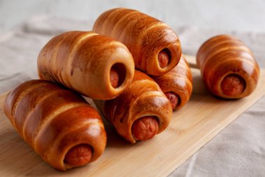 Bambu tahtasında ev yapımı sosisli çörekler, düşük açılı. Yakın plan..