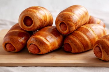 Bambu tahtasında ev yapımı sosisli çörekler, düşük açılı. Yakın plan..