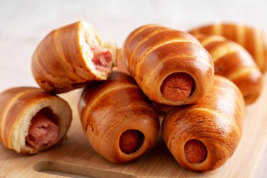 Bambu tahtasında ev yapımı sosisli çörekler, yan görüş. Yakın plan..