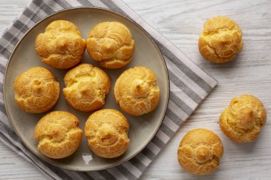 Tabakta ev yapımı Fransız Mini Kremalı Puflar, en iyi manzara. Dümdüz, tepeden, yukarıdan. 