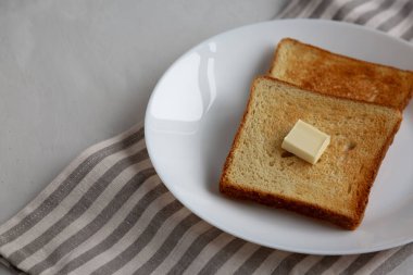 Tabakta tereyağlı ev yapımı tost ekmeği dilimi..