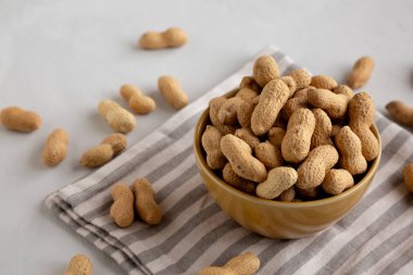 Bir kasede organik çiğ yer fıstığı, yan görünüm.