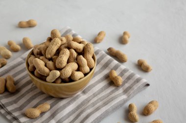 Bir kasede organik çiğ yer fıstığı, yan görünüm.