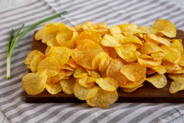 Tahtada soğanlı patates cipsi, yan görünüm.