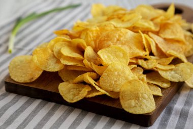 Tahtada soğanlı patates cipsi, yan görünüm.