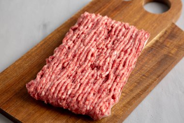 Organik Çimen Fed Çiğ Sığır eti Tahta üzerinde Tahta, yan görünüm.