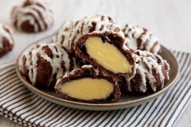 Beyaz ahşap arka planda hindistan cevizi kremalı ev yapımı profiteroller. Yakın plan..