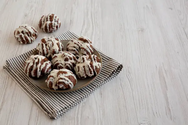 Tabakta Hindistan cevizi kremalı ev yapımı profiteroller, yan görüş. Boşluğu kopyala.