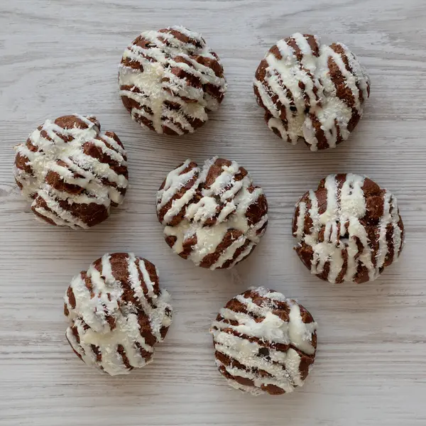 Beyaz ahşap arka planda hindistan cevizi kremalı ev yapımı profiteroller.. 