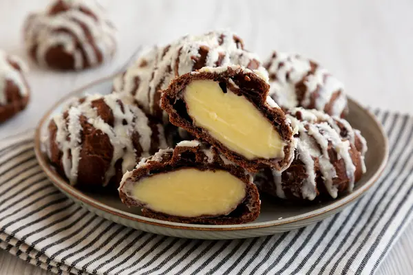 Beyaz ahşap arka planda hindistan cevizi kremalı ev yapımı profiteroller. Yakın plan..