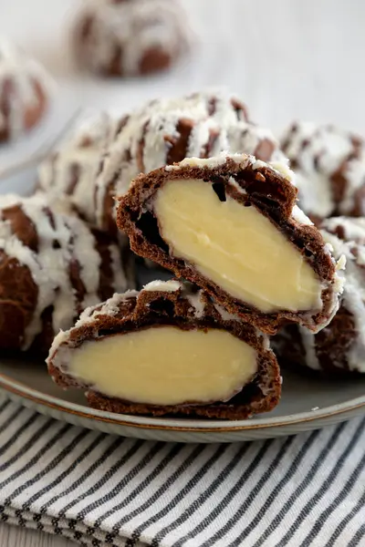 Beyaz ahşap arka planda hindistan cevizi kremalı ev yapımı profiteroller. Yakın plan..