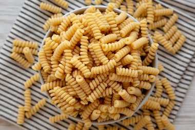 Fırında pişmemiş organik fusilli makarna, en iyi görüntü. Dümdüz, tepeden, yukarıdan.