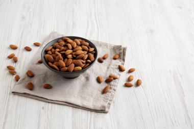 Kavrulmuş badem, bir kasede, yan manzara. Boşluğu kopyala.