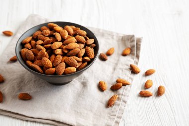 Kavrulmuş badem, bir kasede, yan manzara. Boşluğu kopyala.