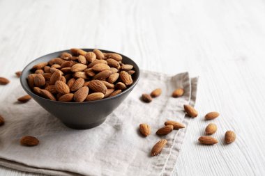 Kavrulmuş badem, bir kasede, yan manzara. Boşluğu kopyala.