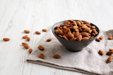 Kavrulmuş badem, bir kasede, yan manzara. Metin için boşluk.