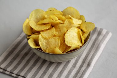 Ev yapımı çaydanlık, patates cipsi ve tuzlu kase, yan görüş..