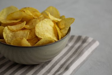 Ev yapımı çaydanlık, patates cipsi ve tuzlu kase, yan görüş..