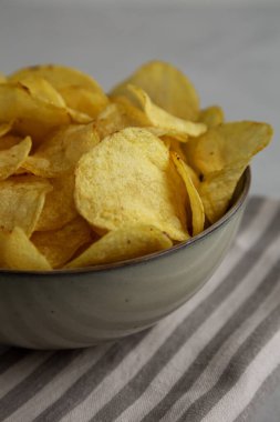 Ev yapımı çaydanlık, patates cipsi ve tuzlu kase, yan görüş.. 