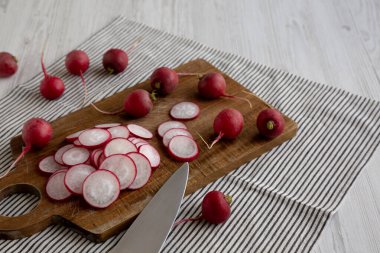 Kesme tahtasındaki çiğ kırmızı turp dilimleri, yan görüş. Boşluğu kopyala.