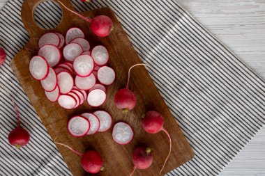 Kesme tahtasındaki çiğ kırmızı turp dilimleri. Metin için boşluk.