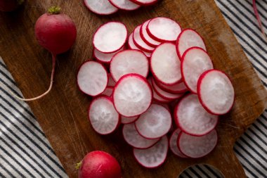 Kesme tahtasındaki çiğ kırmızı turp dilimleri. Düz uzanın, başınızın üstünde.