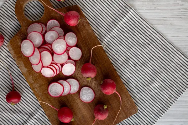 Kesme tahtasındaki çiğ kırmızı turp dilimleri. Metin için boşluk.