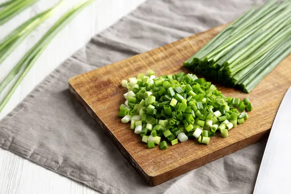 Tahta üzerinde organik kesilmiş yeşil soğan soğanı, yan görüş..