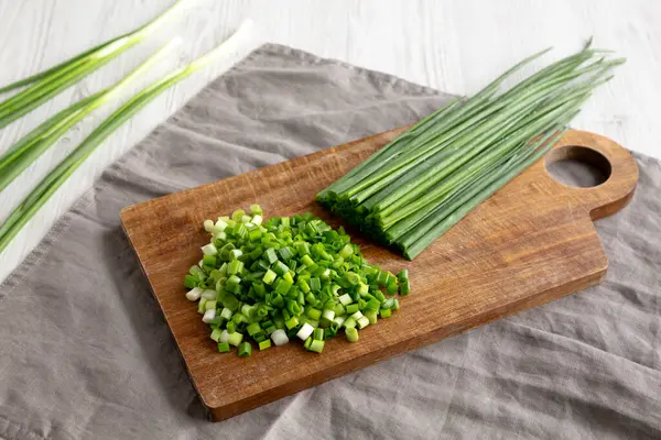Tahta üzerinde organik kesilmiş yeşil soğan soğanı, yan görüş..