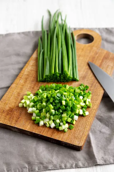 Tahta üzerinde organik kesilmiş yeşil soğan soğanı, yan görüş.. 