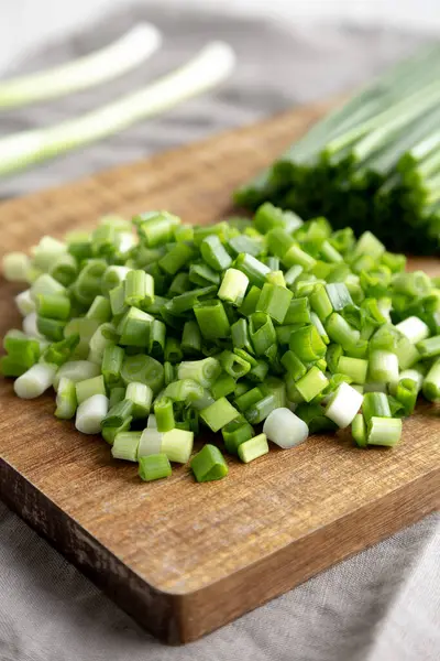 Tahta üzerinde organik kesilmiş yeşil soğan soğanı, yan görüş. Yakın plan..