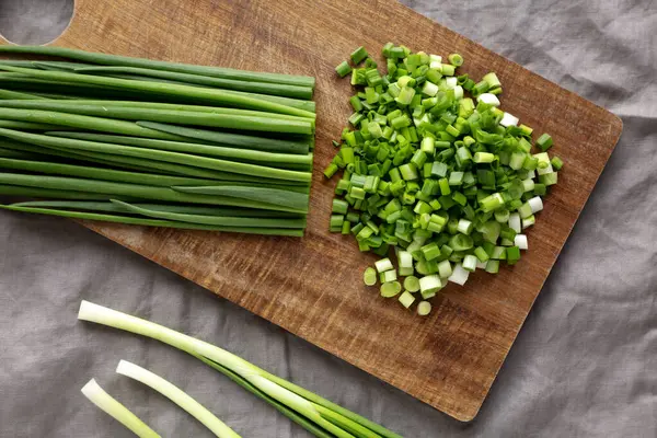 Tahta üzerinde organik kesilmiş yeşil soğan soğanı, üst manzara..